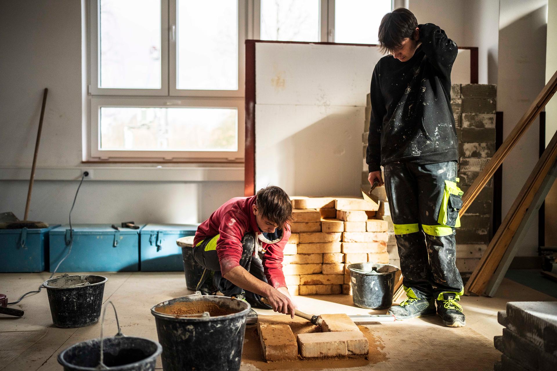 Jednou to budeme dělat i jako práci. Možná. (Zedničtí učni v „tréninkové“ místnosti)