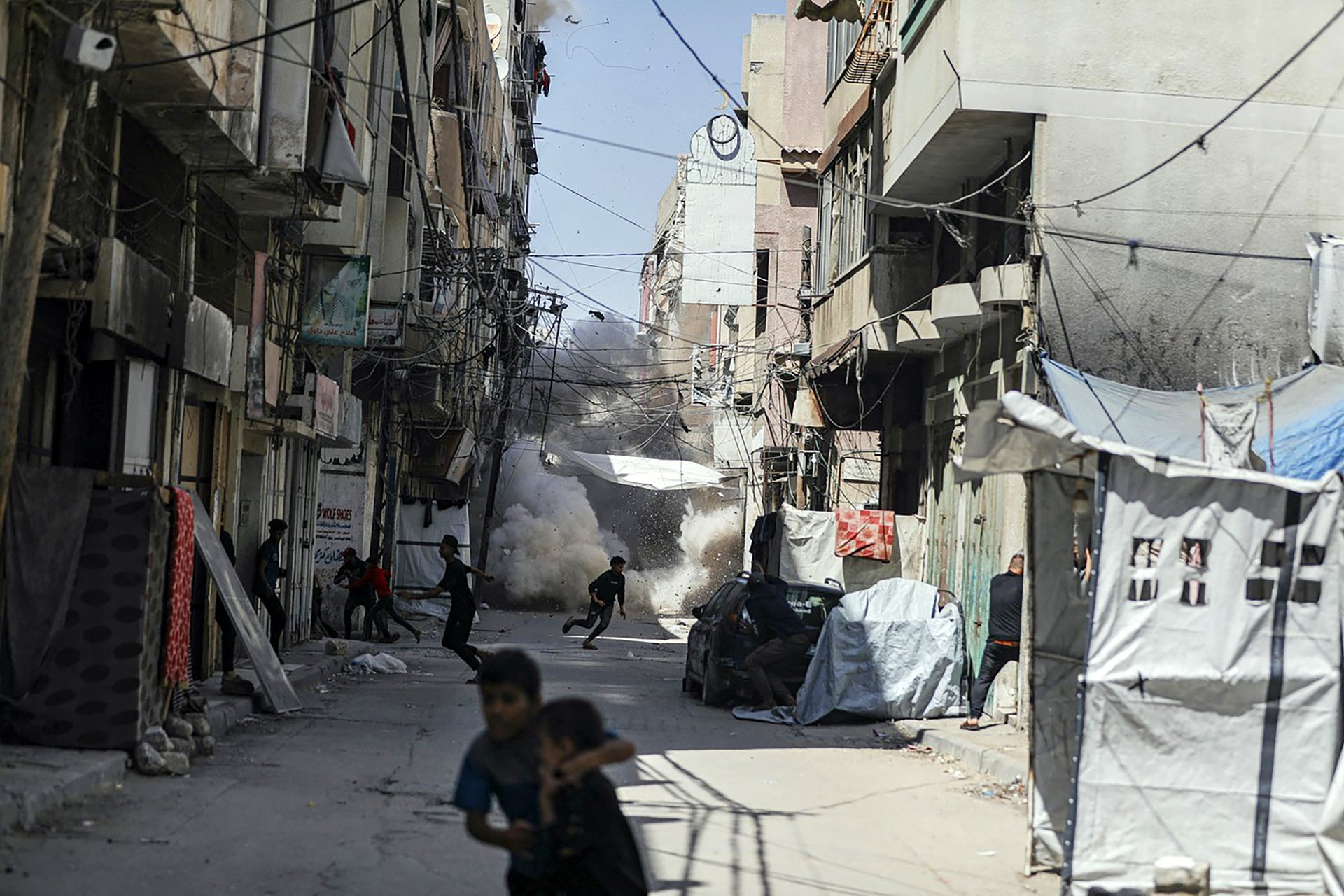 Lidé v Gaza City prchají před bombovým útokem