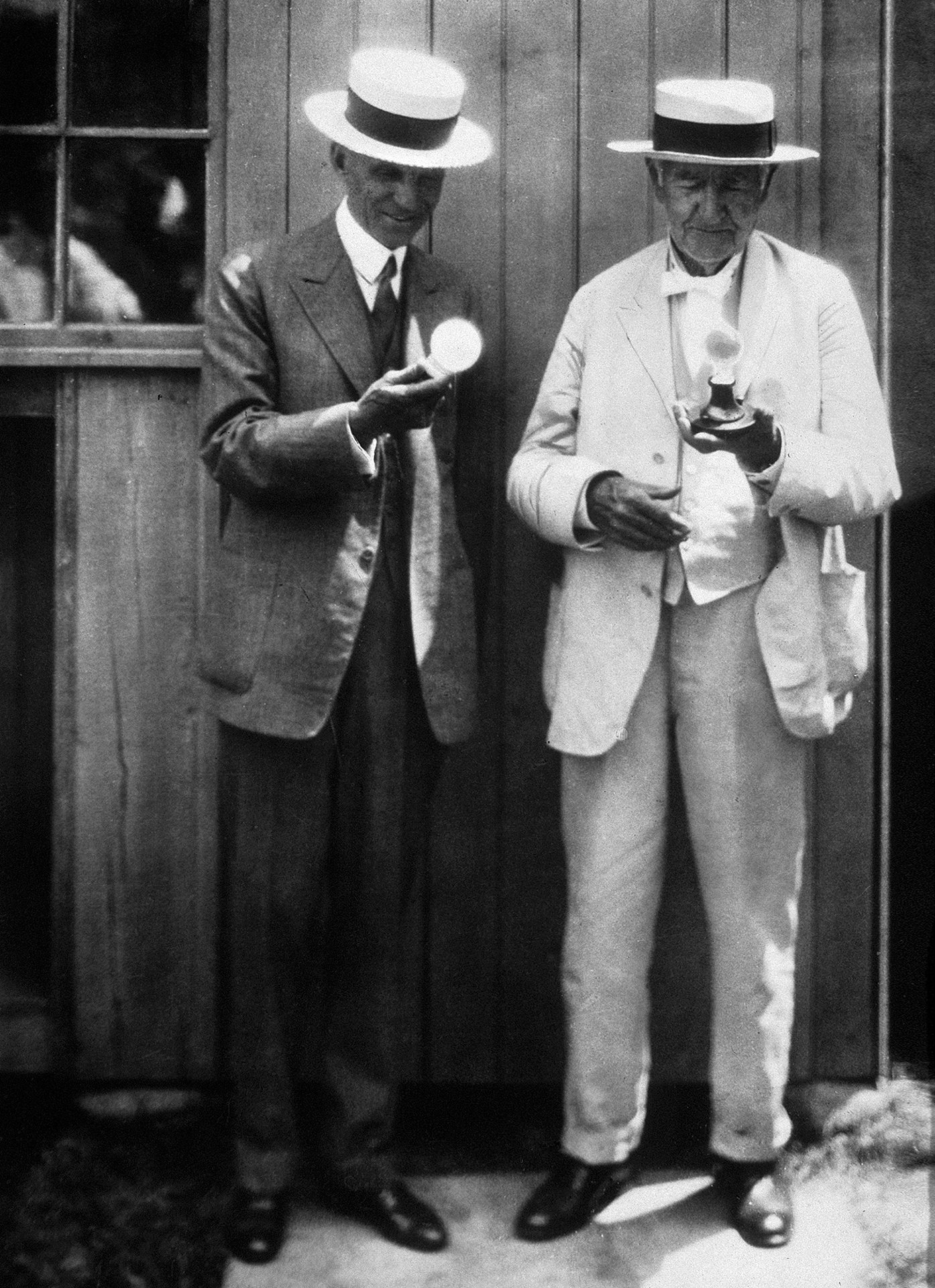 Thomas Alva Edison (vpravo), jehož patenty a vynálezy umožnily rozšíření elektrického světla, ukazuje podnikateli Henrymu Fordovi příklady svých žárovek