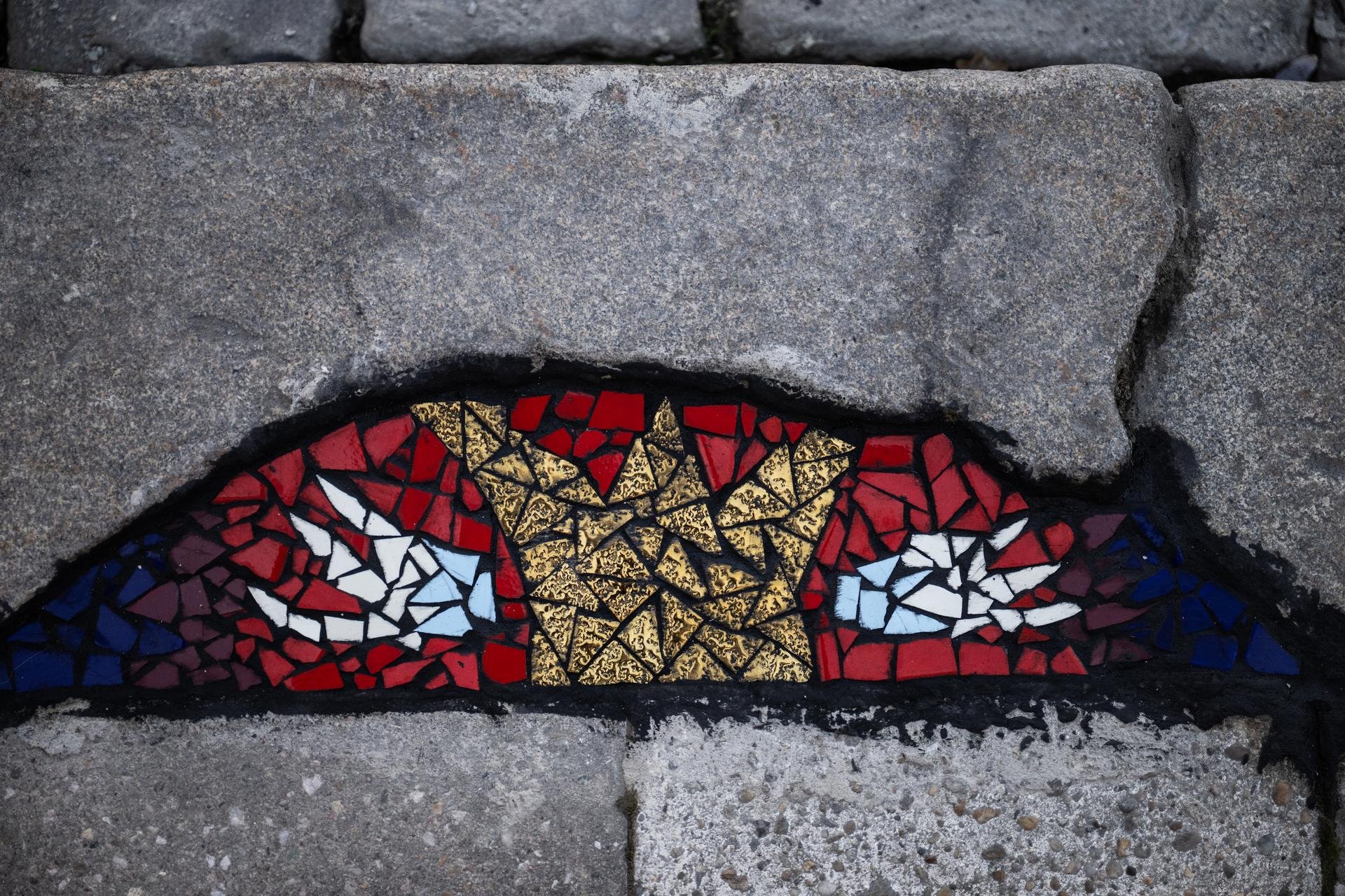 Díra v obrubníku zřejmě zůstala po odstraněném víku kanálu. Teď ji zdobí obraz. 